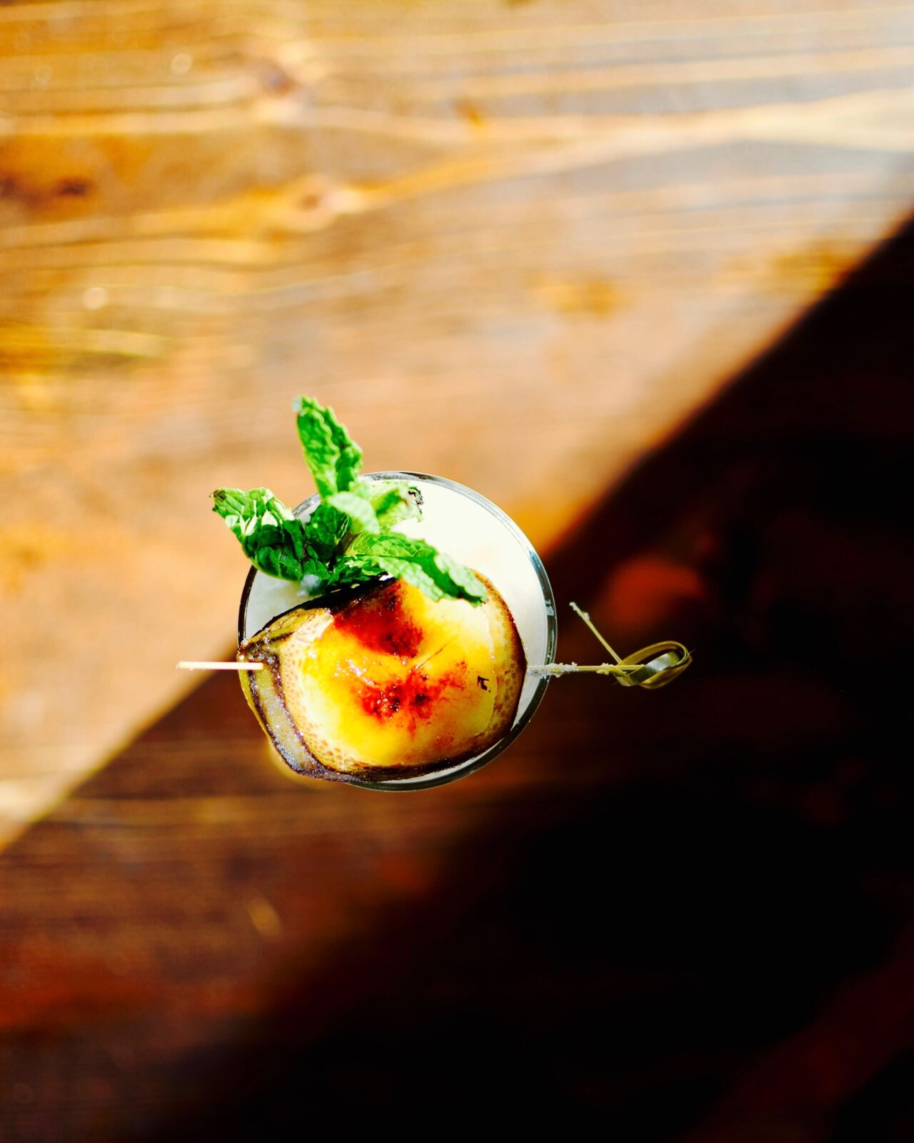 A finished cocktail with a bright citrus garnish in afternoon light