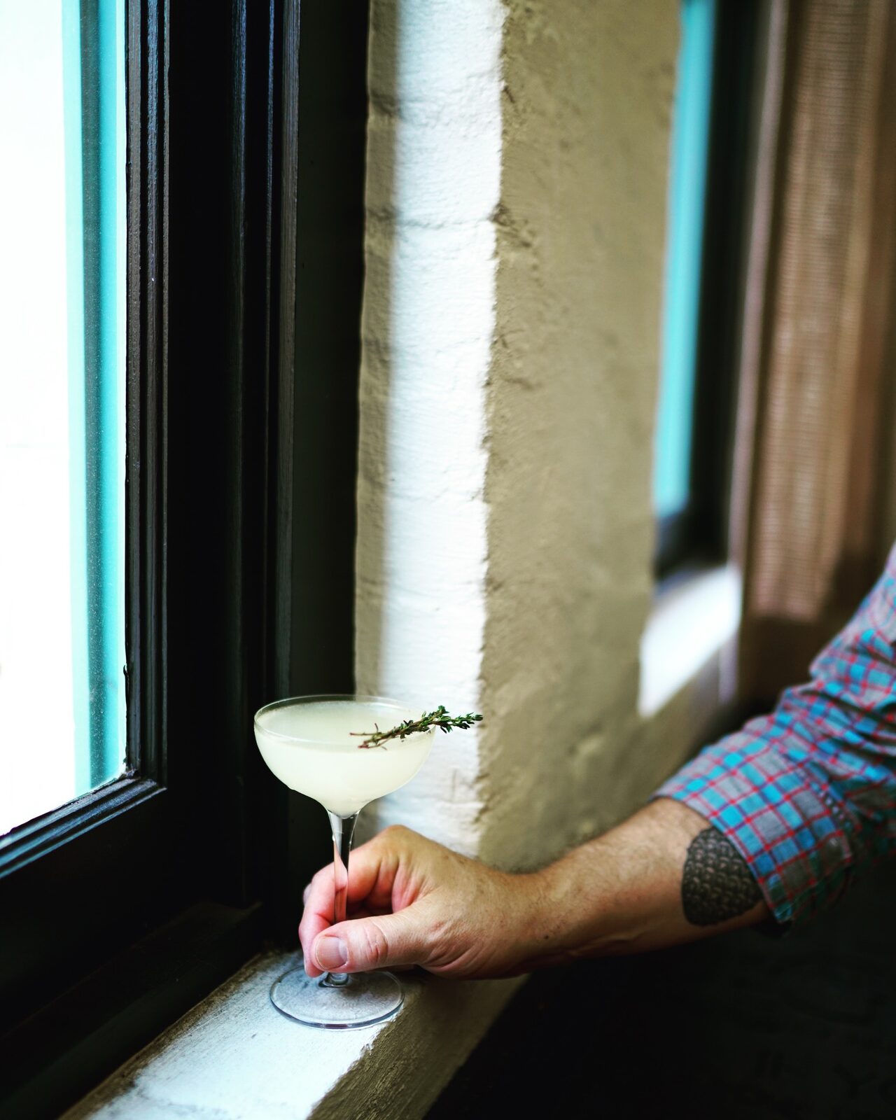A hand working carefully beside a sunlit window